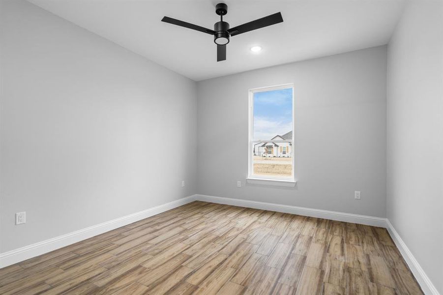 Empty room with light hardwood / wood-style flooring and ceiling fan