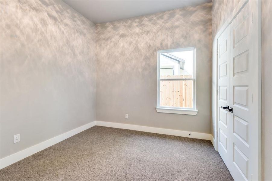 Carpeted spare room featuring baseboards