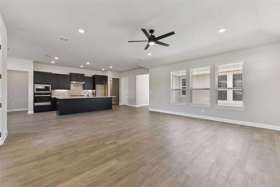 Unfurnished living room featuring a ceiling fan, baseboards, wood finished floors, and recessed lighting Unfurnished living room featuring a ceiling fan, baseboards, wood finished floors, and recessed lighting
