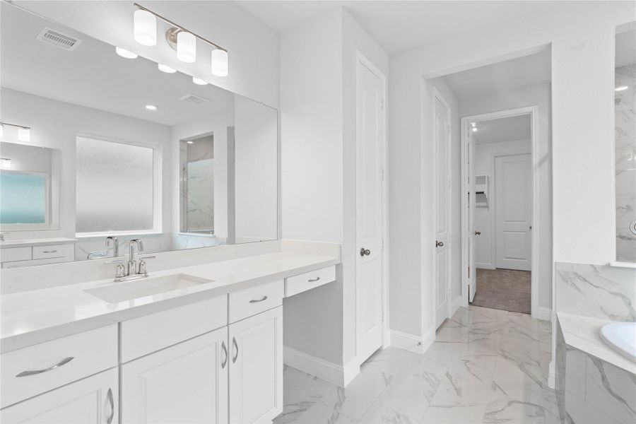 Modern primary bath features dual vanities with sleek cabinetry, quartz countertop, and crisp chrome fixtures for a truly contemporary feel. Modern primary bath features dual vanities with sleek cabinetry, quartz countertop, and crisp chrome fixtures for a truly contemporary feel.