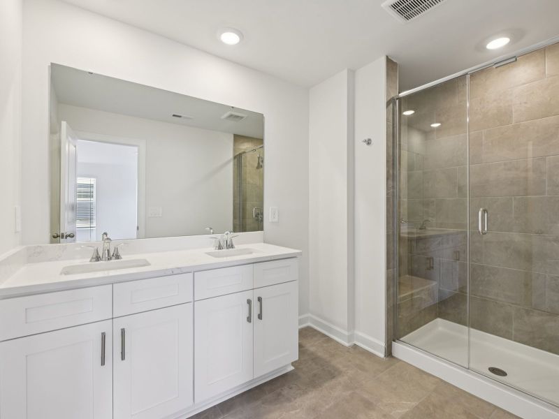 The primary bathroom boasts a dual-sink vanity and modern walk-in shower. The primary bathroom boasts a dual-sink vanity and modern walk-in shower.