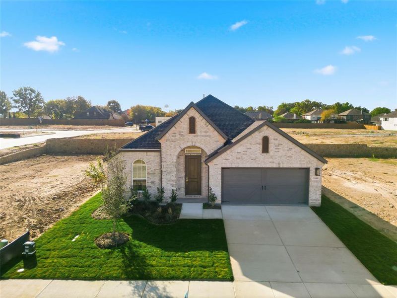 French provincial home with brick siding, driveway, a front lawn, and a garage French provincial home with brick siding, driveway, a front lawn, and a garage