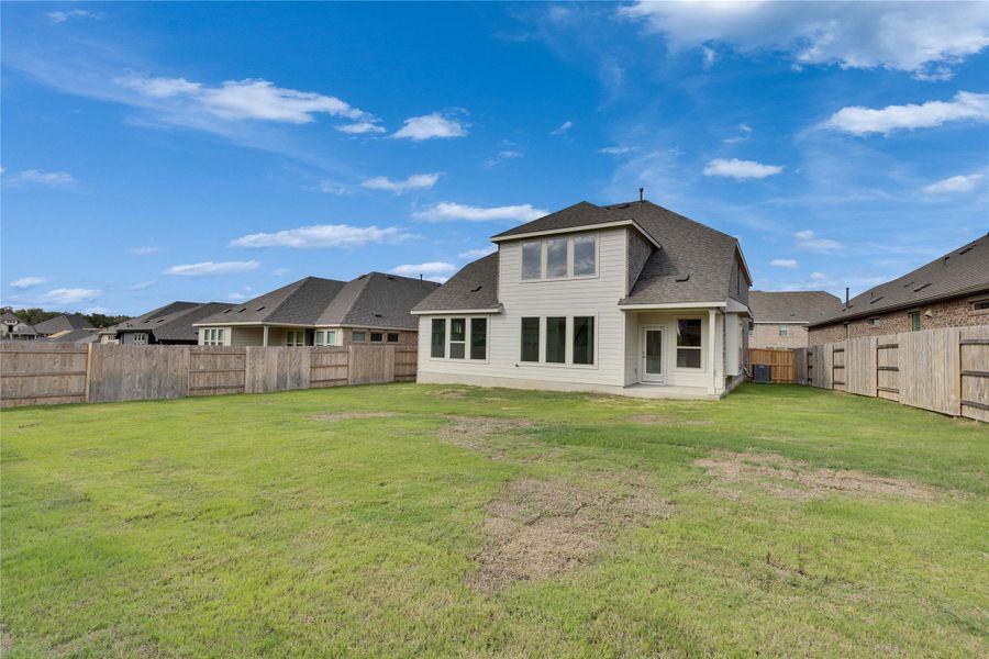 Rear view of house with roof with shingles, a patio area, and a fenced backyard Rear view of house with roof with shingles, a patio area, and a fenced backyard