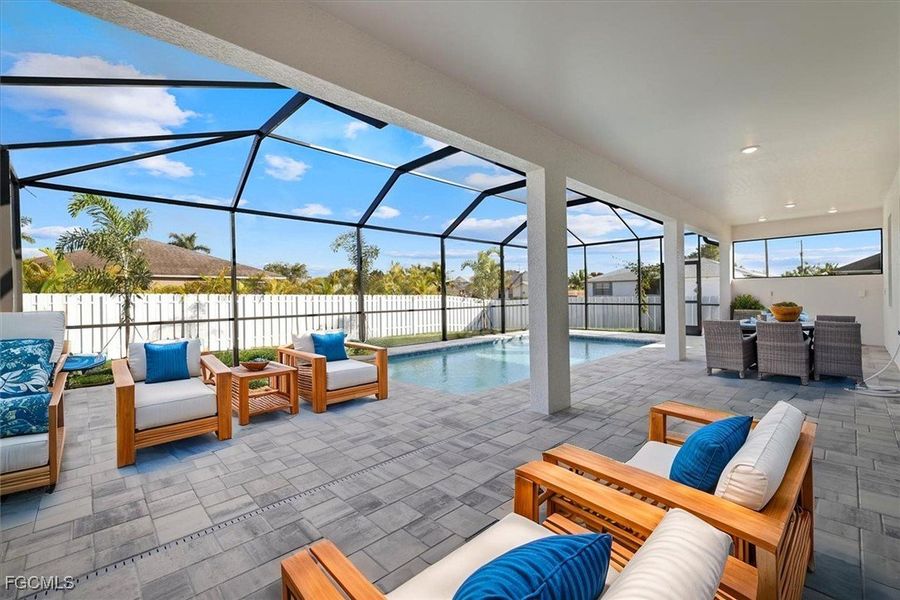 Fenced backyard featuring an outdoor living space, glass enclosure, a sunroom, and a patio area Fenced backyard featuring an outdoor living space, glass enclosure, a sunroom, and a patio area