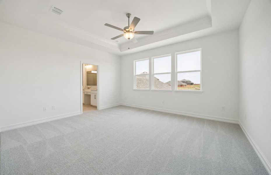 Spacious owner's suite highlighted by large windows and an exquisite tray ceiling *Real home pictured Spacious owner's suite highlighted by large windows and an exquisite tray ceiling *Real home pictured