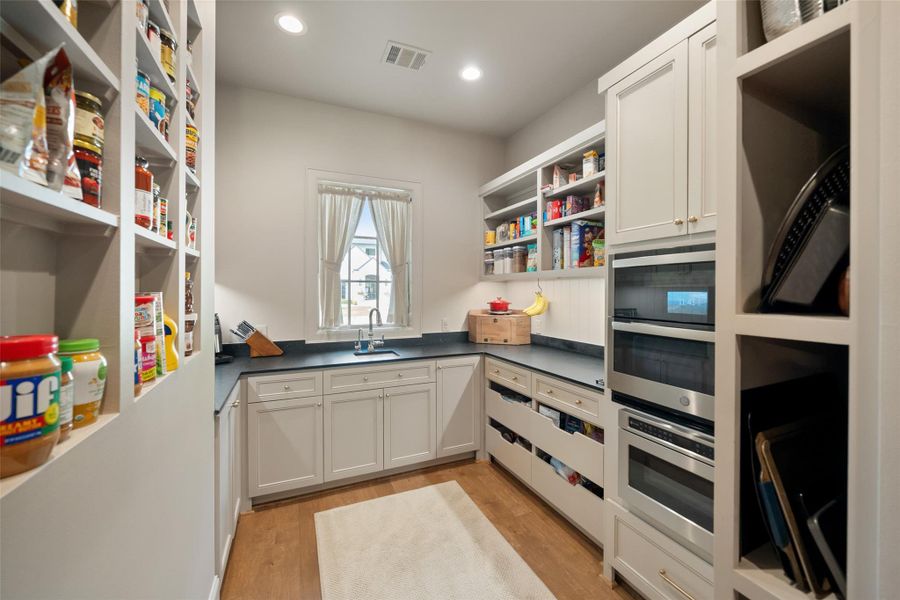 Tucked just off the main kitchen, the scullery offers a hidden workspace with stainless steel appliances and a deep sink. The room can be easily closed off, providing a quiet, functional space for prep, cleanup, or entertaining.
