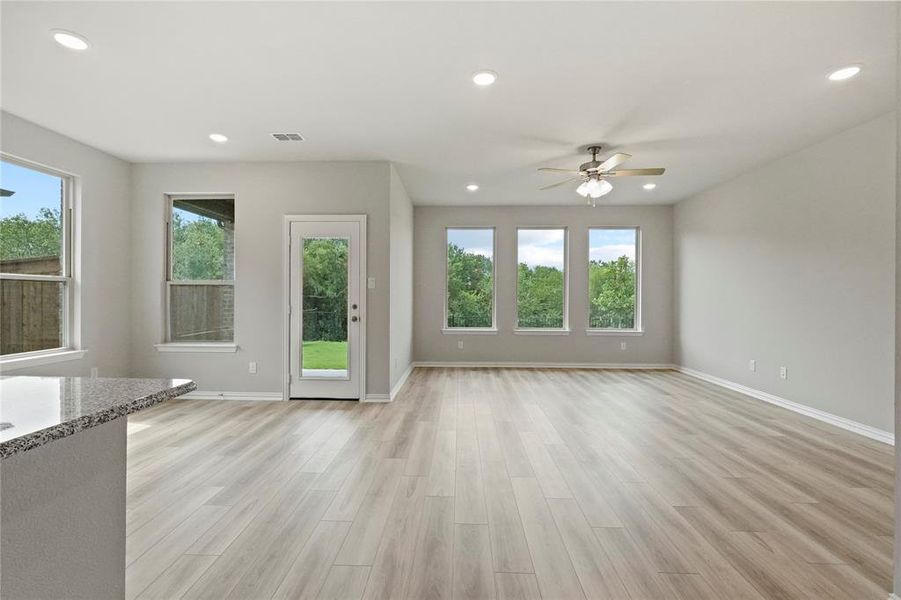 Unfurnished living room featuring ceiling fan and light hardwood / wood-style floors