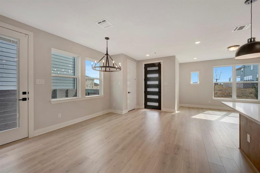 Foyer with light wood-type flooring and a chandelier