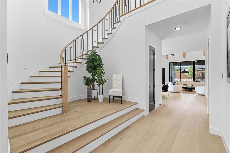 Staircase with wood finished floors and a towering ceiling Staircase with wood finished floors and a towering ceiling