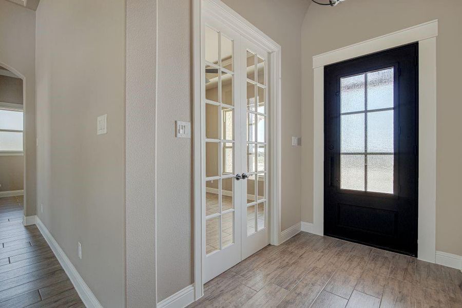 Doorway to outside featuring french doors, light hardwood / wood-style flooring, and a healthy amount of sunlight