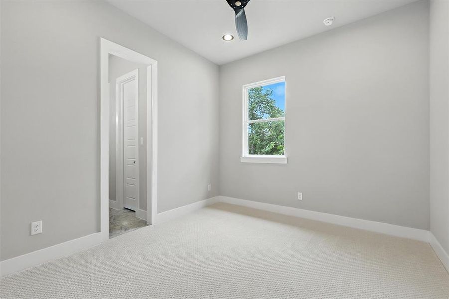 Empty room featuring light colored carpet, a ceiling fan, and recessed lighting