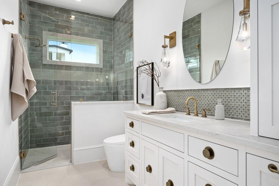 A well-appointed bathroom features a glass-enclosed shower, elegant vanity with stone counters, and tasteful fixtures.