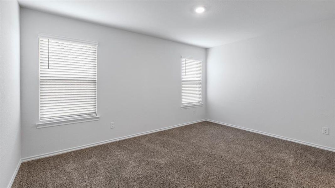 Spare room with dark carpet and baseboards