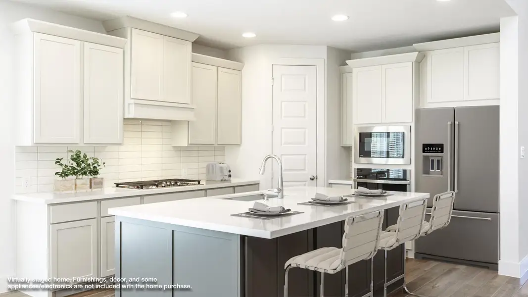 Kitchen featuring appliances with stainless steel finishes, tasteful backsplash, a breakfast bar area, recessed lighting, and wood finished floors