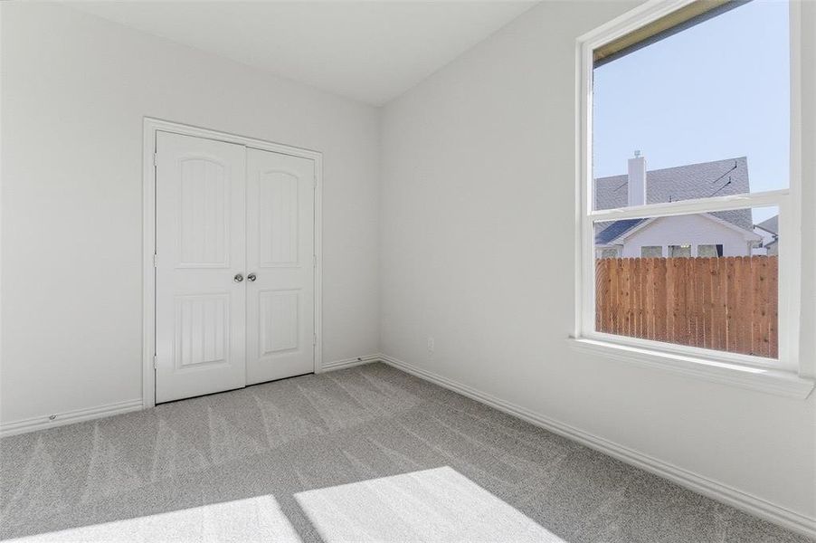 Unfurnished bedroom featuring light carpet and a closet