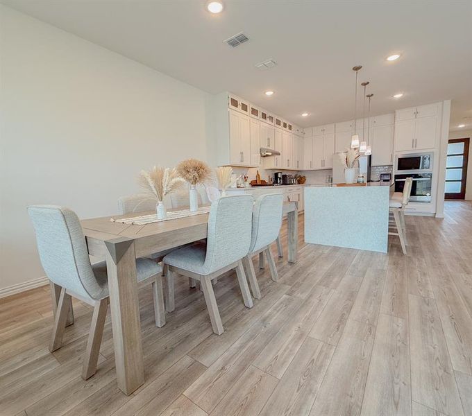 Dining space featuring light wood-type flooring, visible vents, baseboards, and recessed lighting