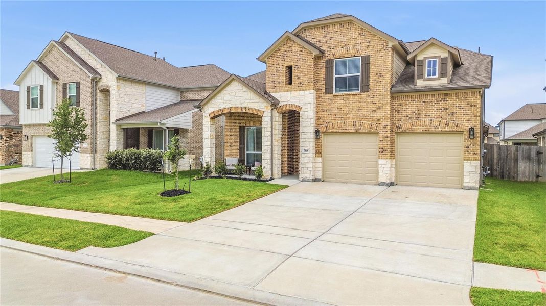 This attractive brick-and-stone elevation, complemented by manicured landscaping and a wide driveway, creates a welcoming first impression and timeless appeal.