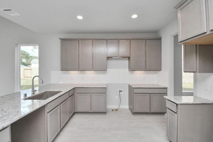 The kitchen is a culinary haven, featuring granite countertops, a tile backsplash, stainless steel appliances, 42” upper cabinets, and undercabinet lighting. The kitchen is a culinary haven, featuring granite countertops, a tile backsplash, stainless steel appliances, 42” upper cabinets, and undercabinet lighting.