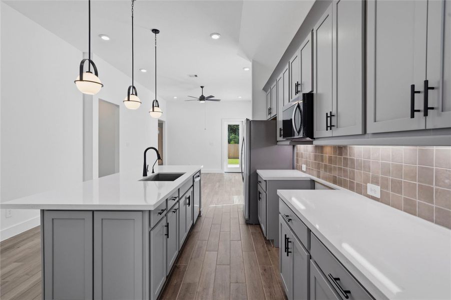 The chef's kitchen boasts timeless shaker-style cabinetry in an upscale grey tone, beautifully accented by modern black hardware and a cohesive tile backsplash. The chef's kitchen boasts timeless shaker-style cabinetry in an upscale grey tone, beautifully accented by modern black hardware and a cohesive tile backsplash.