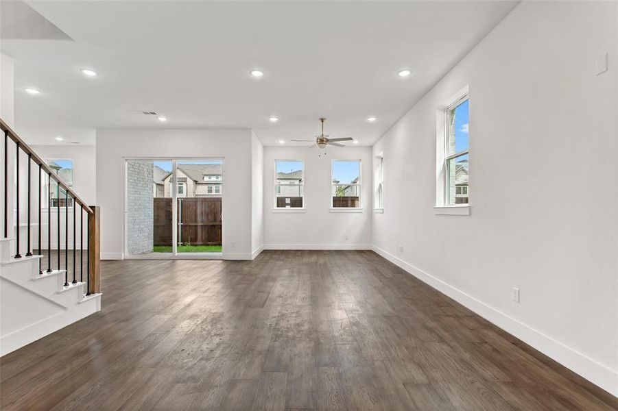 Unfurnished living room with ceiling fan and dark wood-type flooring