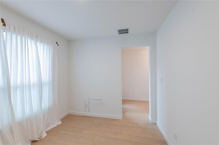 Spare room featuring light wood-style floors and baseboards