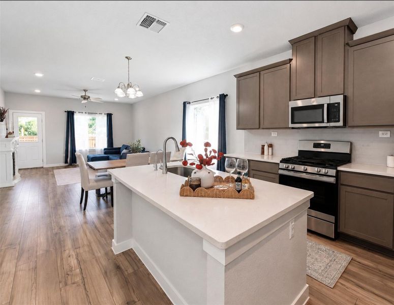 An open layout kitchen flows effortlessly into the dining area with durable wood flooring throughout. An open layout kitchen flows effortlessly into the dining area with durable wood flooring throughout.