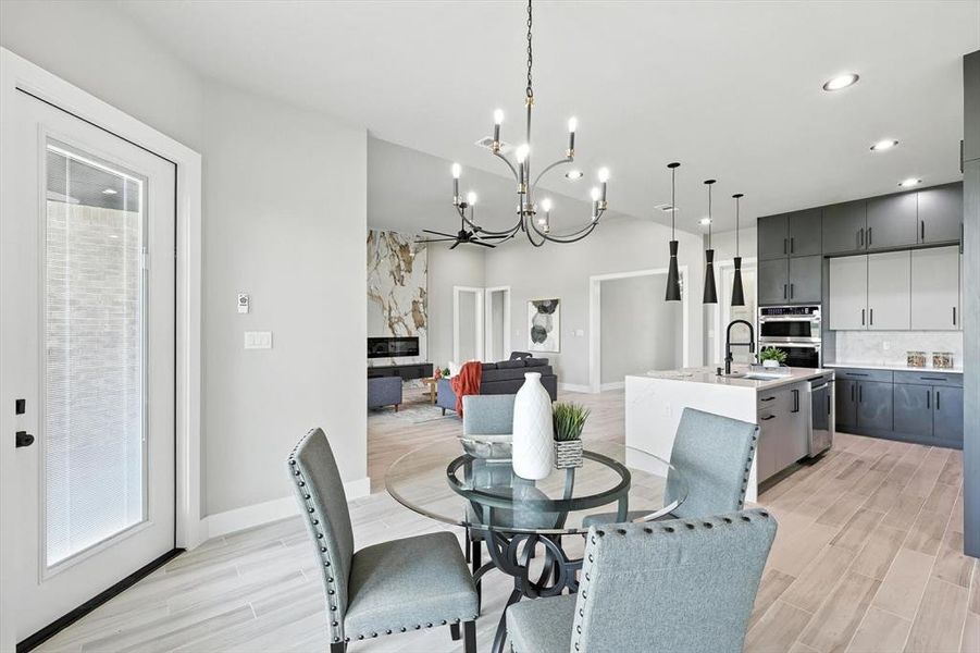 Dining room with light wood-style flooring, a chandelier, and recessed lighting Dining room with light wood-style flooring, a chandelier, and recessed lighting