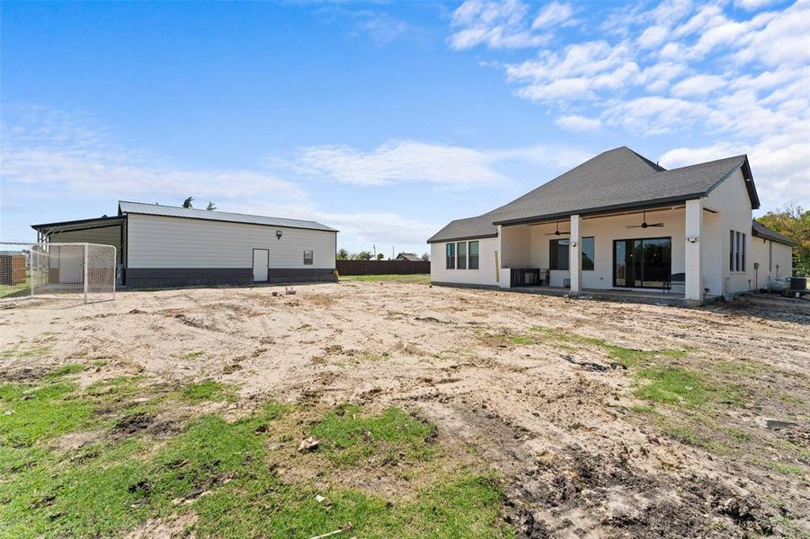 Rear view of property with a ceiling fan, a patio, and a shingled roof Rear view of property with a ceiling fan, a patio, and a shingled roof