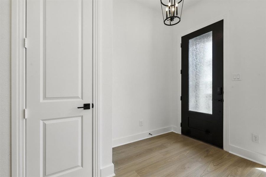 Foyer with light wood-style floors and a chandelier Foyer with light wood-style floors and a chandelier