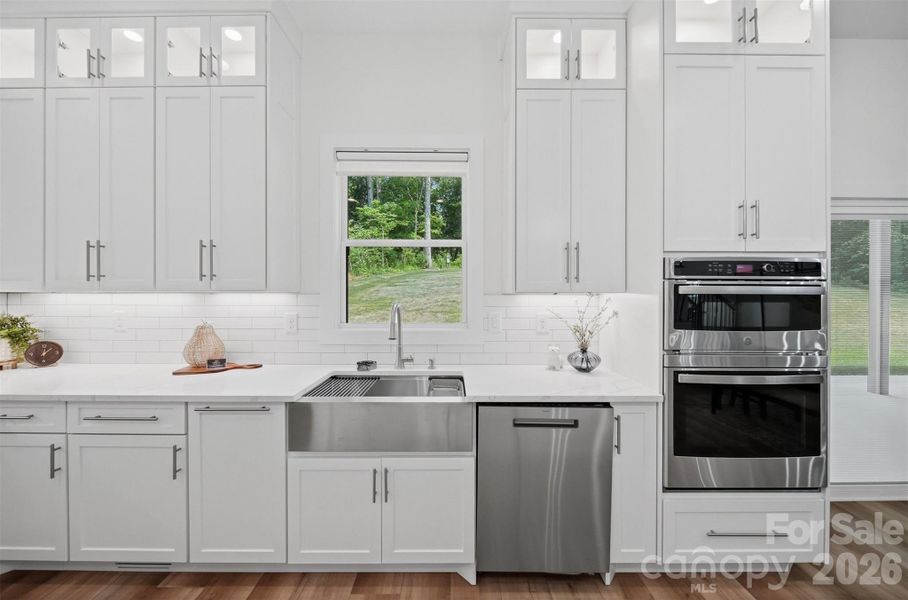 Sleek stainless appliances, subway tile backsplash, and warm flooring add the perfect contrast