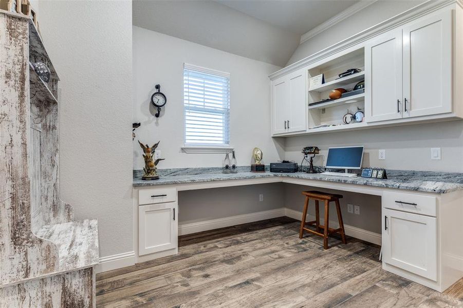 Office space with built in study area and light wood-type flooring