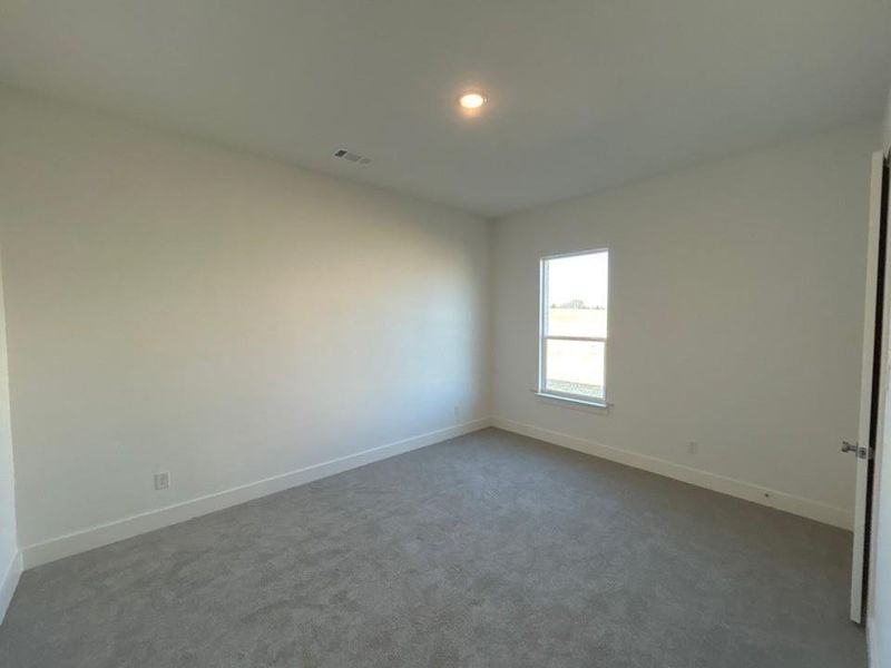 Empty room featuring dark carpet and recessed lighting