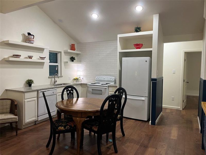 Kitchen featuring wood-finish flooring, white cabinetry, and granite countertops