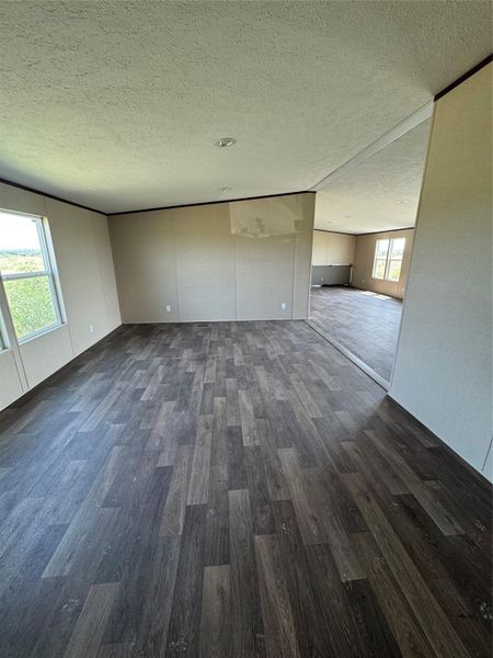 Rich wood-look flooring and tall windows define this open interior layout.