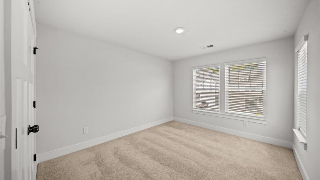 Inviting bedroom with tasteful finishes and large windows that create a fresh, open ambiance