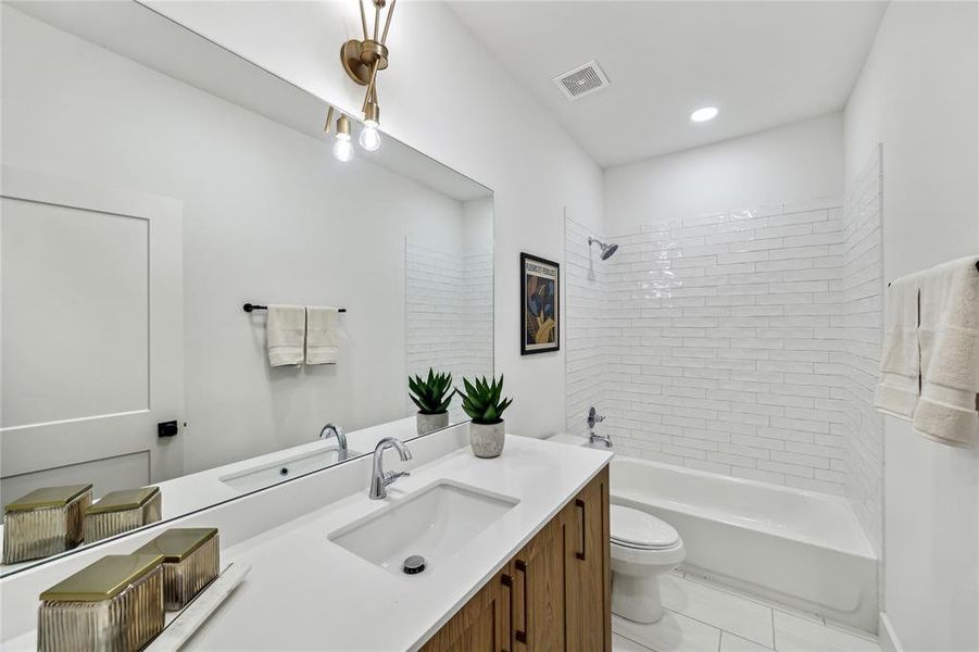 Sleek and modern guest bathroom featuring chic fixtures, a spacious vanity, and a stylish tiled shower. Perfect for comfort and elegance.