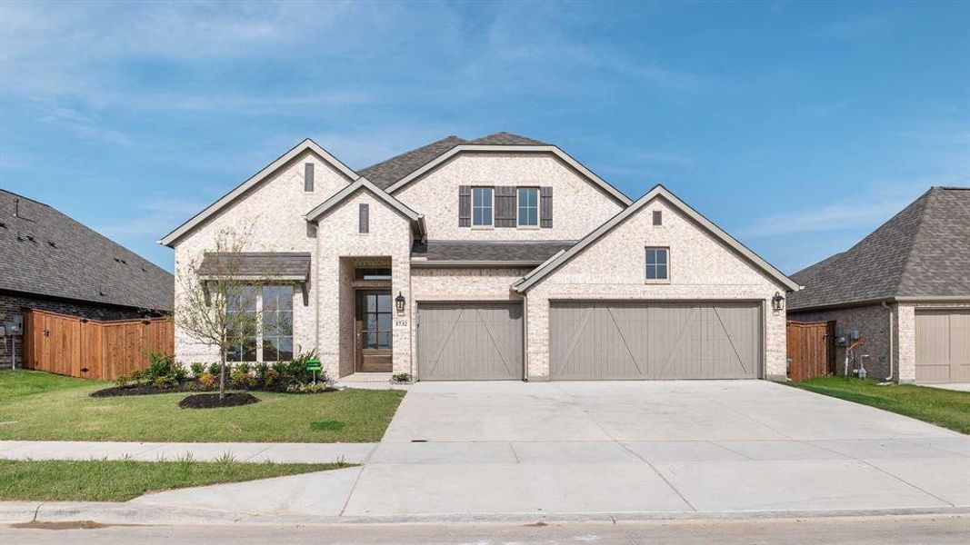 View of front of home with a garage and a front yard