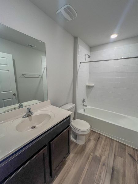 Full bathroom featuring light wood-style flooring, shower / washtub combination, and vanity