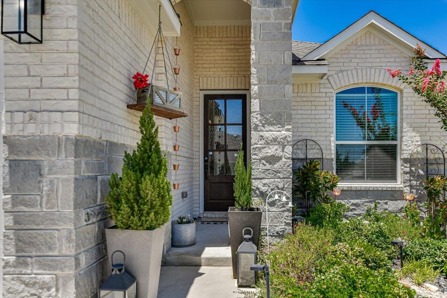 A welcoming stone and brick facade is enhanced by thriving garden landscaping and a dark-paneled front door. A welcoming stone and brick facade is enhanced by thriving garden landscaping and a dark-paneled front door.