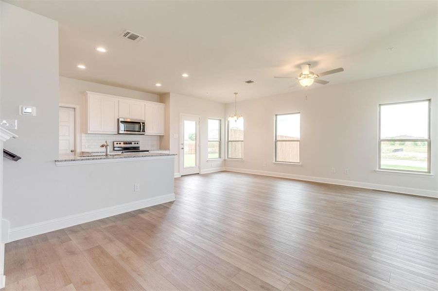 Unfurnished living room featuring ceiling fan and light hardwood / wood-style flooring