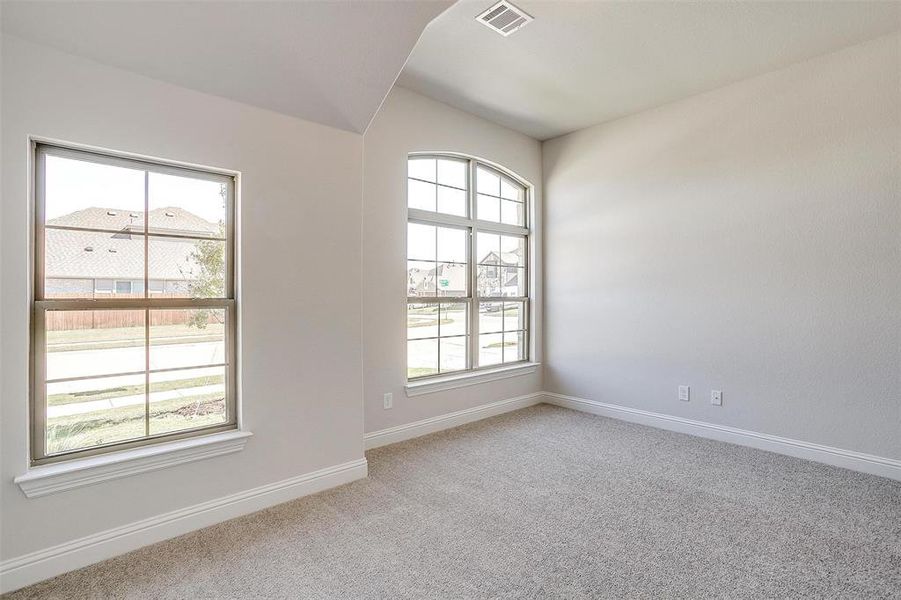 Carpeted empty room featuring a wealth of natural light