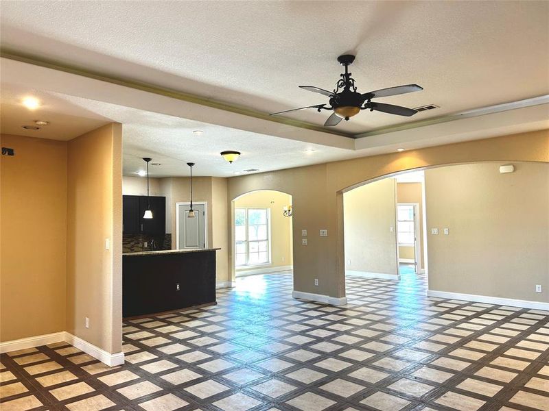 Unfurnished living room with ceiling fan and a textured ceiling