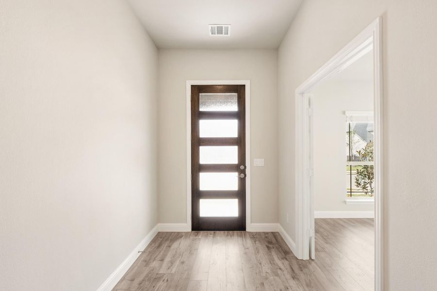 Entryway with dark wood front door featuring glass panels and light hardwood floors