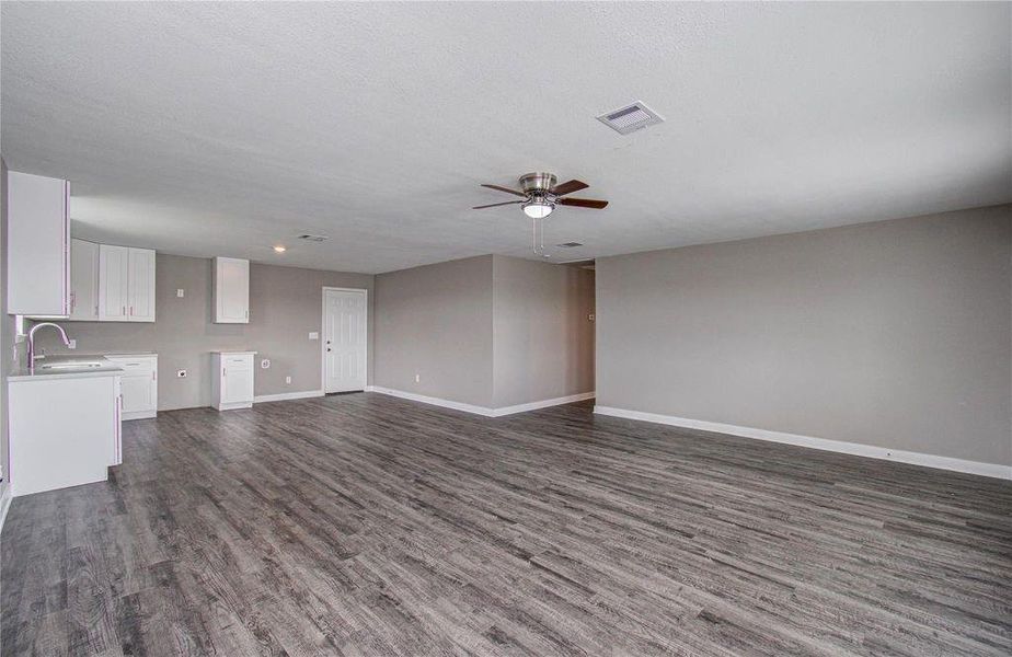 A wide-angle view highlighting the seamless flow between the kitchen and living area.