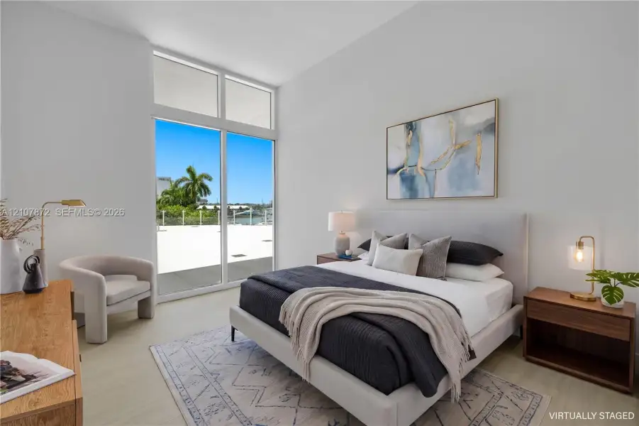 High-ceilinged room featuring wood-finish flooring, floor-to-ceiling glass paneling, and an expansive exterior terrace High-ceilinged room featuring wood-finish flooring, floor-to-ceiling glass paneling, and an expansive exterior terrace