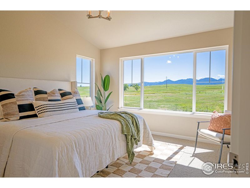 Primary bed with vaulted ceilings and unobstructed mountain views.