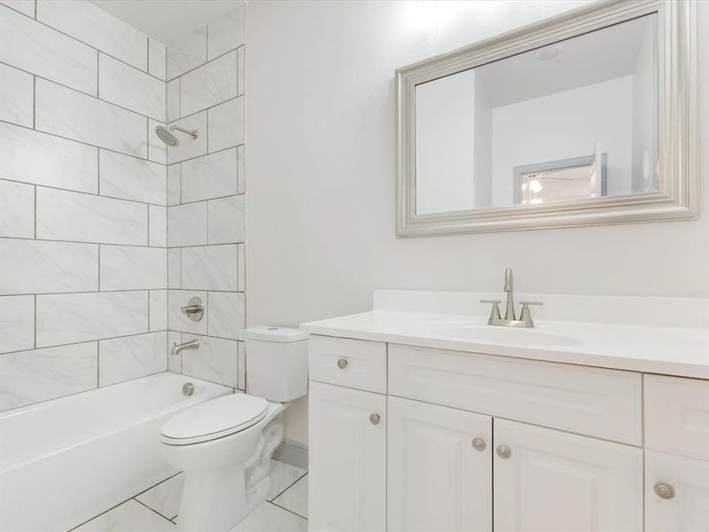 Bathroom with tub / shower combination, vanity, and light tile patterned floors