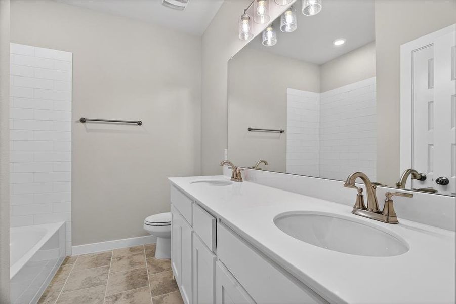 Bathroom featuring a double vanity with white cabinetry and integrated sinks Bathroom featuring a double vanity with white cabinetry and integrated sinks