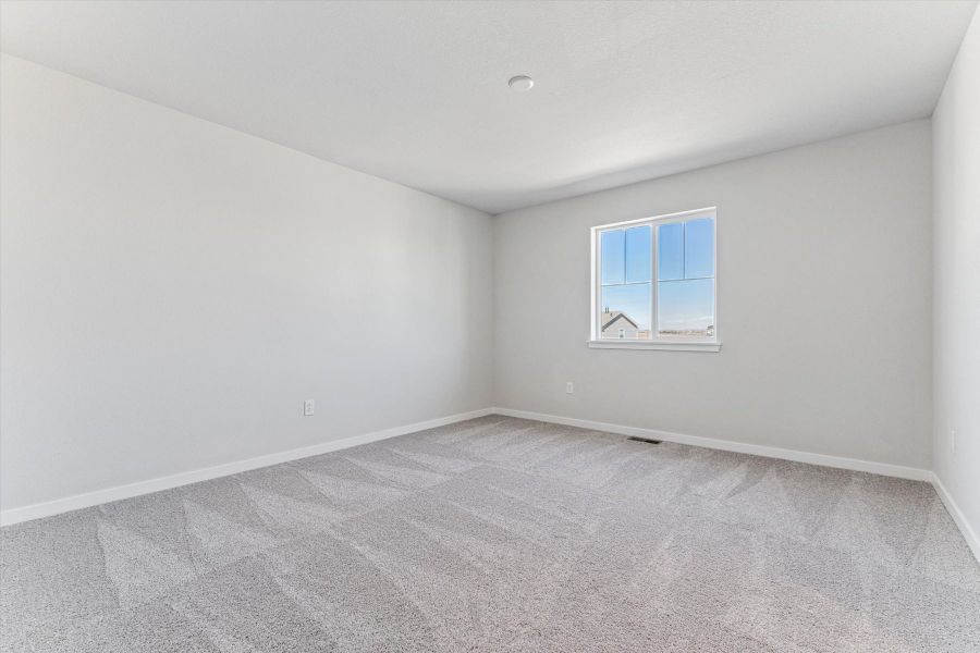 A room with a window and a carpet.