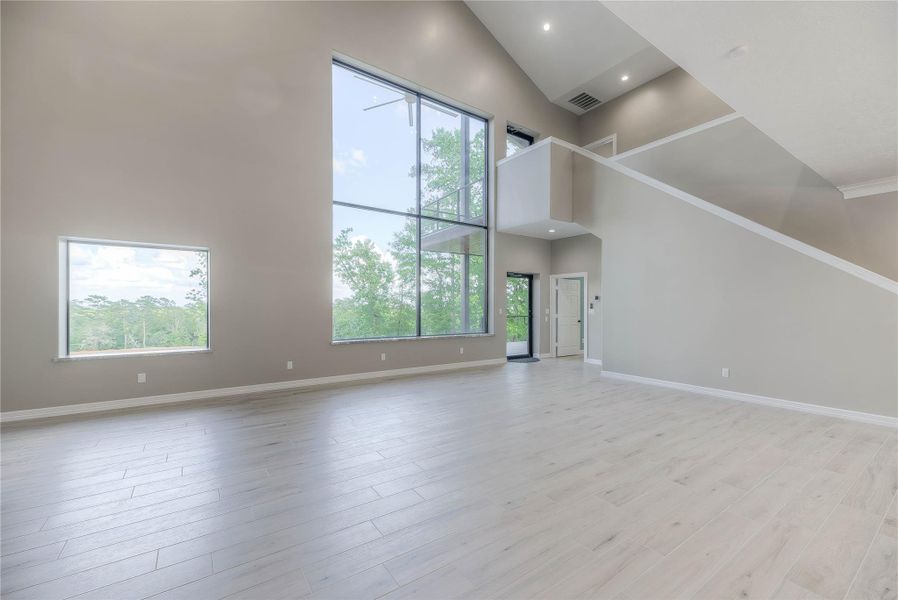 Living room view showing the stairs and upstairs balcony with huge 16x12 window overlooking beautiful pond (Building B) Living room view showing the stairs and upstairs balcony with huge 16x12 window overlooking beautiful pond (Building B)